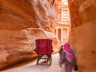 people in a horse carriage in a gorge, Siq canyon in Petra, Jordan. Petra is one of the New Seven...