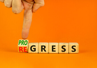 Regress or progress symbol. Businessman turns wooden cubes and changes the word Regress to Progress. Beautiful orange table orange background. Business regress or progress concept. Copy space.