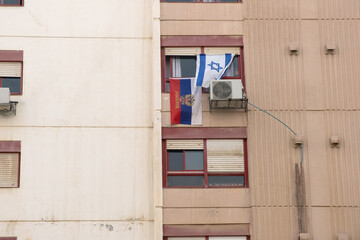 The national Israeli and Russian flag hangs outside the window of an Israeli apartment building....