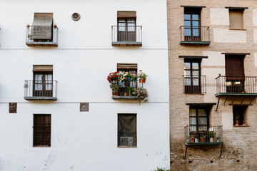 Facade of a house in the Albaicín neighborhood, Granada, with a typical Andalusian balcony full of...