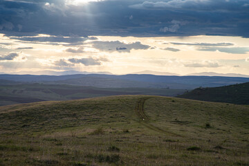 Fototapeta premium amazing sunset sky over green hills in early summer