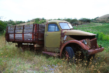 The front of the cab of a rusty abandoned truck of unknown brand