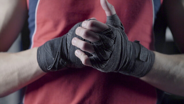 Man flexing his fists before a fight. Close-up of a young Thai boxer hands hemp ropes are wrapped before the fight or training