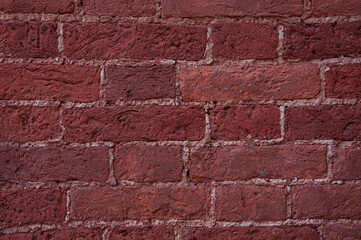 Texture of the wall of a building made of ancient red-brown brick close-up