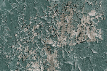 Texture of an old stone painted green wall with cracks close up