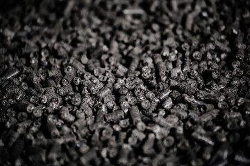 Black bio fuel pellets, close up view, selective focus