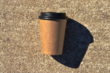 A close-up of a brown cardboard disposable coffee cup. A place for your packaging design.