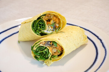 Vegan wrap on a plate. Tasty vegetarian curry wraps with chickpeas. Healthy meat free snack food...