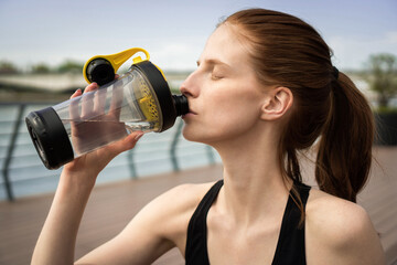 Sportswoman drinking water after hard workout