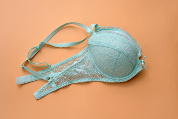 Green bra with lace on a beige background. Bra pale blue with pushap folded in two. Beautiful lingerie.