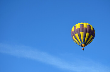Fototapeta na wymiar beautiful yellow blue hot air balloon against the blue sky, copy space