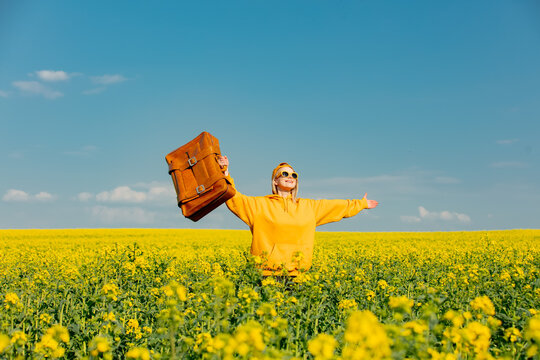 Ukrainian Woman In Yellow Hoodie With Bag In Rapeseed Field