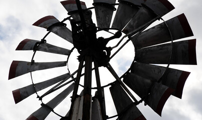 Windmill on black displayed outdoors.