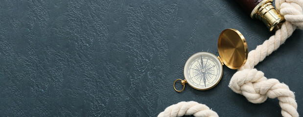 Vintage compass and rope on dark background with space for text