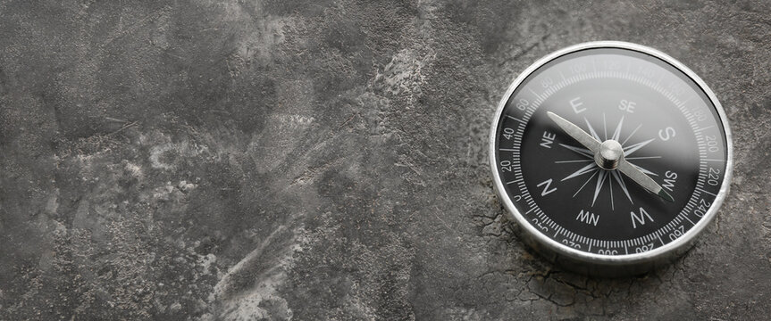 Compass on grey background with space for text