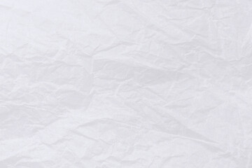 Abstract background of textural crumpled white paper. Wrapping paper randomly crumpled texture close-up. Can be used as background or overlay.
