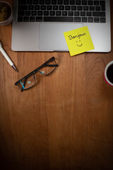 Illustration du bien-être et du bonheur au travail. Un papier autocollant est collé sur un ordinateur portable avec le mot bonjour et un sourire dessiné. © Tof - Photographie