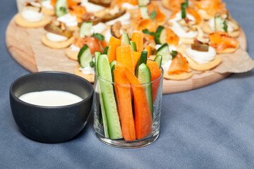 Crudites, set of fresh raw vegetables cut into thin strips with cheese sauce. Canapes. Selective focus