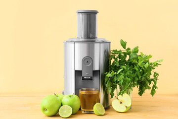 New modern juicer and glass of fresh juice with apples on wooden table