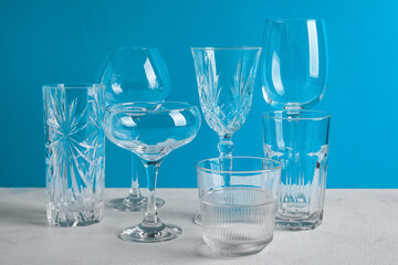 Different empty glasses on blue background