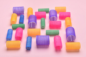 Different hair curlers on color background