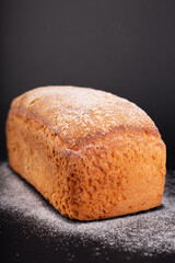 close up french lean bread with flour on a black background. Concept recipe of handmade bread