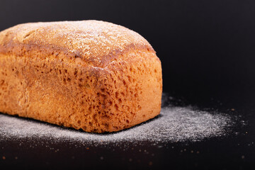 close up french lean bread with flour on a black background. Concept recipe of handmade bread