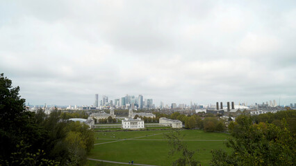 Obraz premium Green glade with old architectural building on background of city. Action. Green glade with old architectural building on background of city