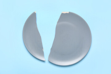 Broken ceramic plate on blue background
