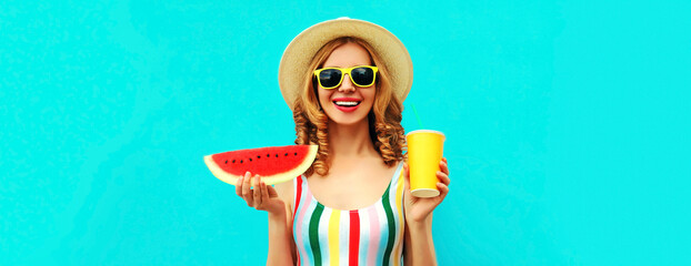 Summer portrait of cheerful smiling young woman with slice of watermelon and cup of juice wearing straw hat posing on blue background, blank copy space for advertising text