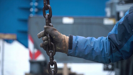 Worker touches the crane hooks to the loops during repair work. Clip. Worker keeps the chain of the...