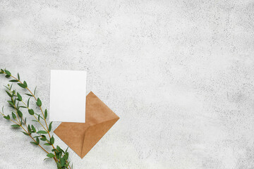 Envelope with blank card and eucalyptus branches on light background