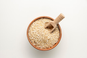 Spelt bran and grains in clay pot isolated on white background