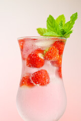  Strawberry drink.Summer drinks.Refreshing cocktail.mineral water in glass with strawberries. Mineral water with ice and strawberries in a glass goblet and ripe strawberries with leaves.