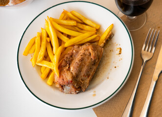 Tasty pork knuckle with potatoes and stewed peppers served at plate