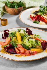 Set of vegetables salads on concrete background. Composition with grilled vegetables salad and salmon salad. Aesthetic composition with healthy food. Summer menu concept.