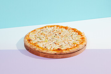 Italian pizza with chicken and pineapple on coloured background. Hawaiian pizza with chicken in minimal style on purple and blue colours. American pizza delivery concept with color backdrop