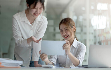 Young Asian businesswoman work together to analysis from work at the office.