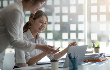 Fototapeta premium Two beautiful young asian businesswoman working together using digital tablet at office.