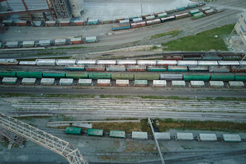 Aerial view of cargo train cars loaded with construction goods at mining factory. Railway transportation of industrial production raw materials