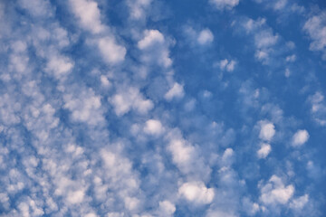 Bright landscape of white puffy clouds spread on blue clear sky