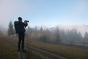 Fototapeta na wymiar Photographer hiker taking picture of nature with digital camera