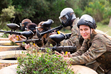 Portrait of team of happy adult people playing on paintball battlefield outdoor