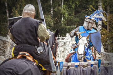 A knight at a medieval tournament fighting his opponent - equestrian cosplay