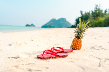 Summer beach vacation with pineapples and flip flops on the beach