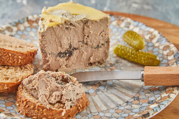 Chicken liver pate with truffles with bread knife and pickles