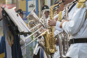 Obraz premium KOLKATA, WEST BENGAL , INDIA - JANUARY 17TH 2016 : Kolkata Police Force Officers, dressed in white and black suits, are playing band, using various musical instruments, in a winter morning.
