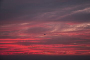 An airliner flying through the red clouds