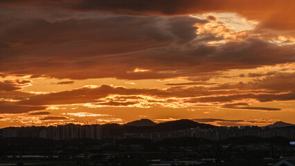 The cityscape under the cloudy sunset