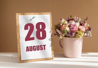 august 28. 28th day of month, calendar date.Bouquet of dead wood in pink mug on desktop.Cork board with calendar sheet on white-beige background. Concept of day of year, time planner, summer month